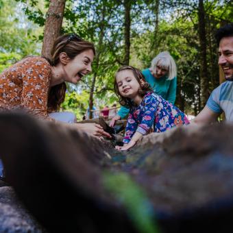 Family playing with water play at the Eden Project's outdoor playground